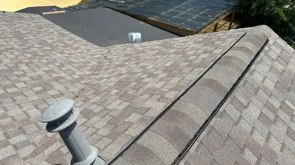 Low hip ridge of a June 2024 roof replacement in the Heights