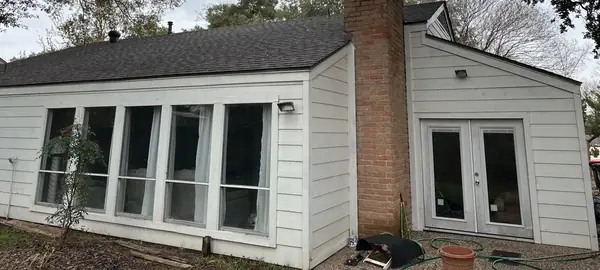 Brick chimney with new flashing on the completed gray roof