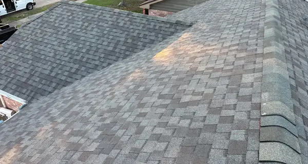 Rear slope of a replaced roof over a backyard fence in Houston, TX