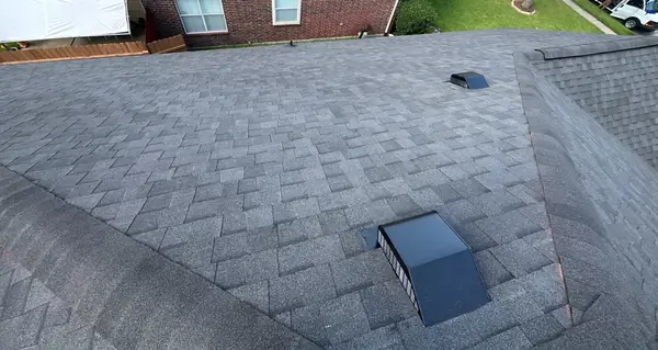 Finished gray shingle roof with new dome vent on a one-story Houston home