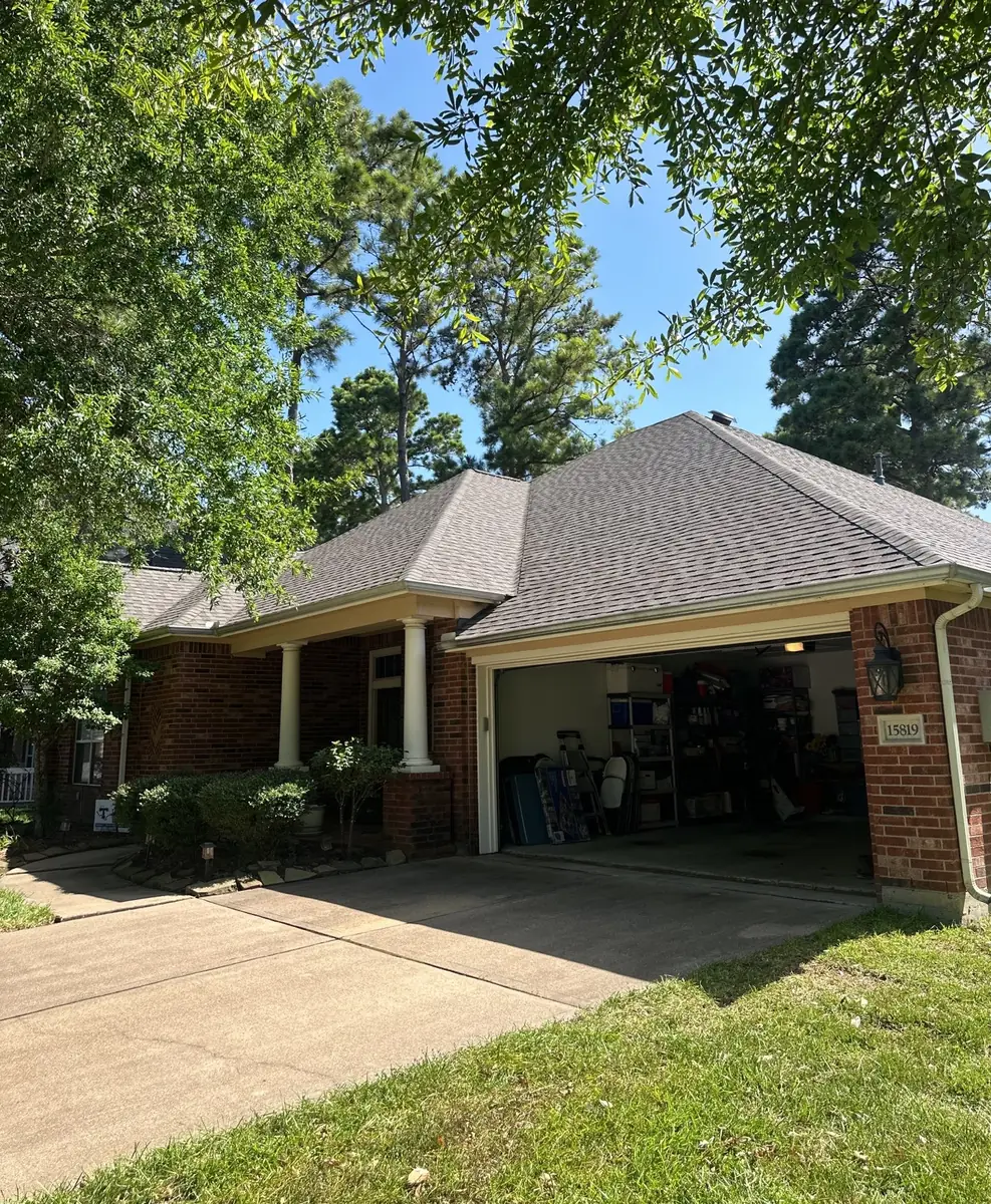 Front of the house showing the new gray architectural shingle roof and garage