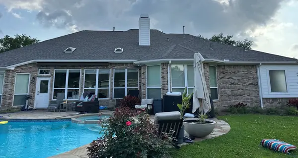 Rear of a Pearland home with a new roof over the patio and pool