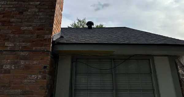 New shingle roof meeting a brick chimney with fresh counter flashing