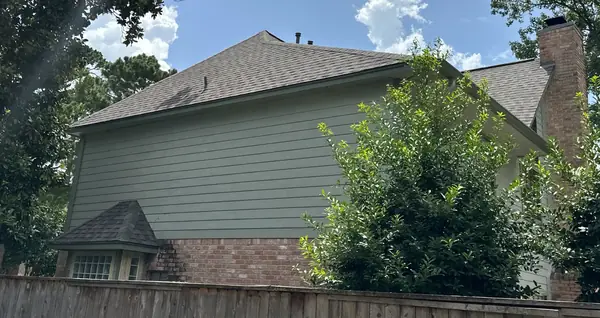 Side elevation of a two-story Kingwood home with the new gray-brown roof