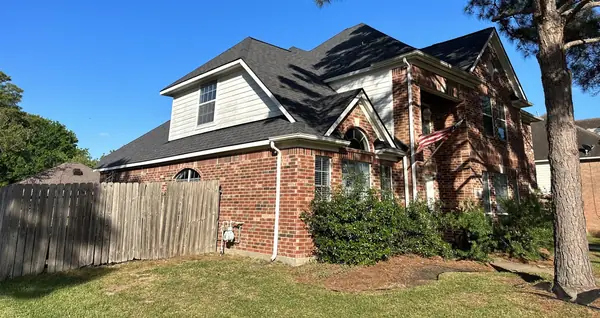 Front of a two-story brick Cypress home with a new Moire Black roof