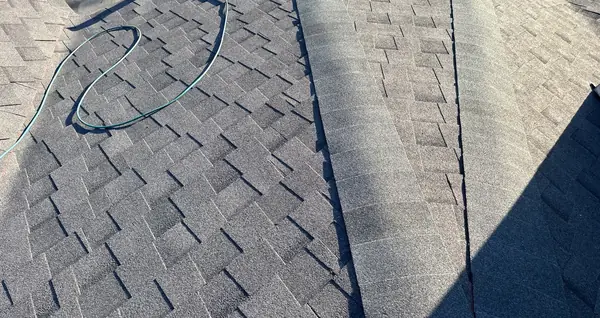 Main ridge of a new gray roof in Spring with ridge vent under the caps