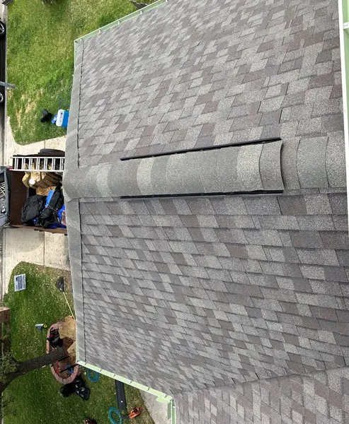 Ridge cap seen from above on a steep Weathered Wood roof in Spring