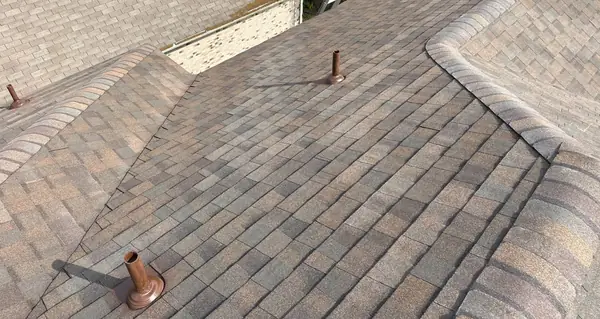 Hip caps and valley of a new tan-brown roof in Cypress