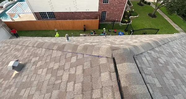 Ridge caps and rear slope of a new Weathered Wood roof in Cypress