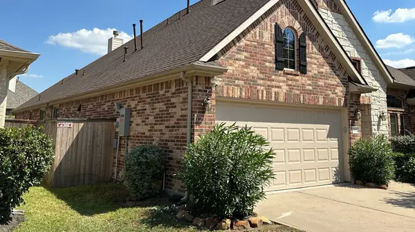 Side elevation and garage of a Katy home with a new Heather Blend roof