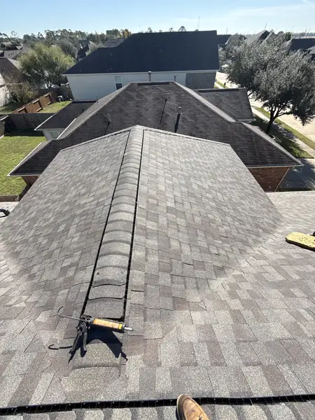 Hip and ridge caps of a new charcoal roof in Cypress