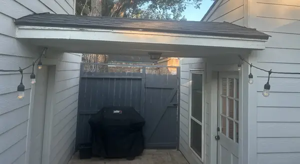 Back porch with new fiber-cement siding under the replaced roof, Katy