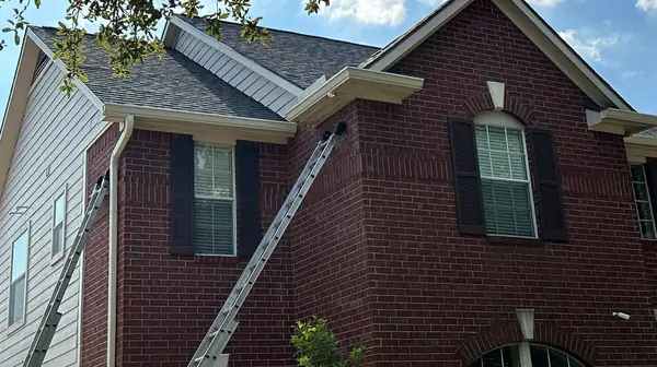 Ladder at the front gable of a two-story Houston home during roofing