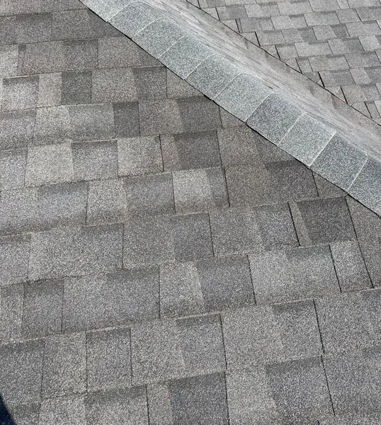 Ridge cap and shingle detail on a replaced roof in 77095