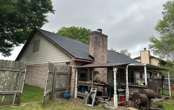 Charcoal laminate roof and brick chimney on a one-story League City home