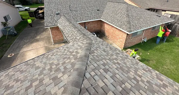 Rear slope of a two-story brick Katy home after roof replacement