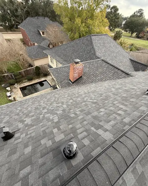 Rear slope of a new shingle roof with chimney flashing
