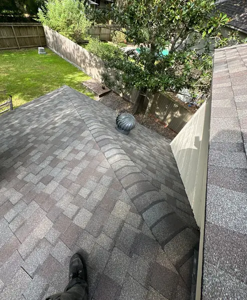 Gray-brown shingle roof under pine trees in Kingwood TX