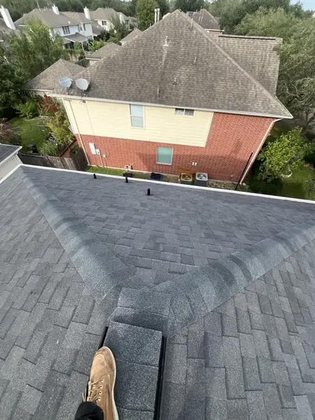 Rear slope of a new laminate roof above a Houston backyard
