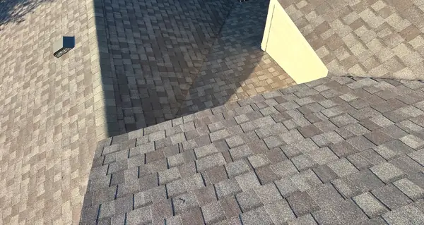Hip and ridge caps of a new tan-brown roof in Cypress