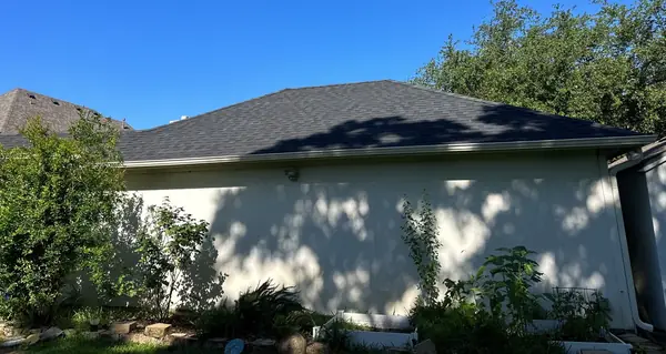 Rear of a two-story house after a June 2025 roof replacement