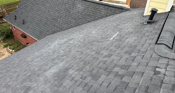 Chimney side of a new roof on a one-story brick house