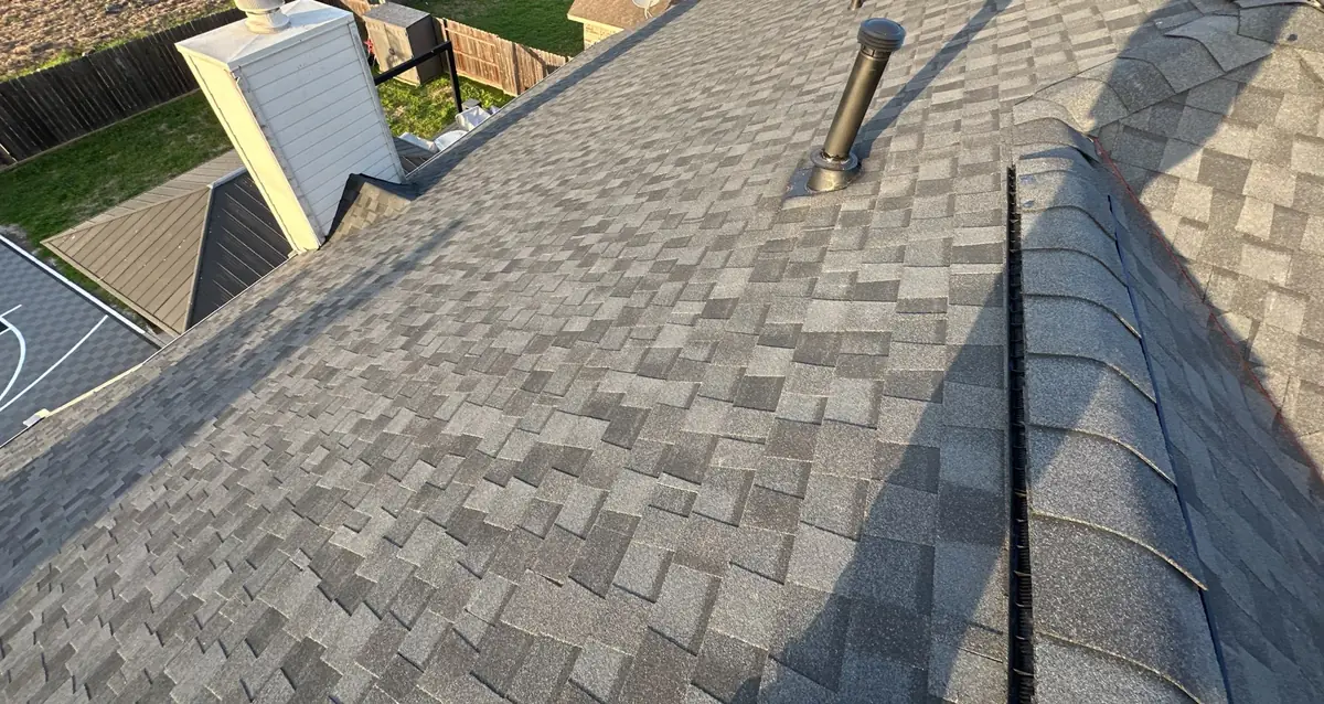 Hip and ridge caps of a new gray roof after storm damage, Cypress